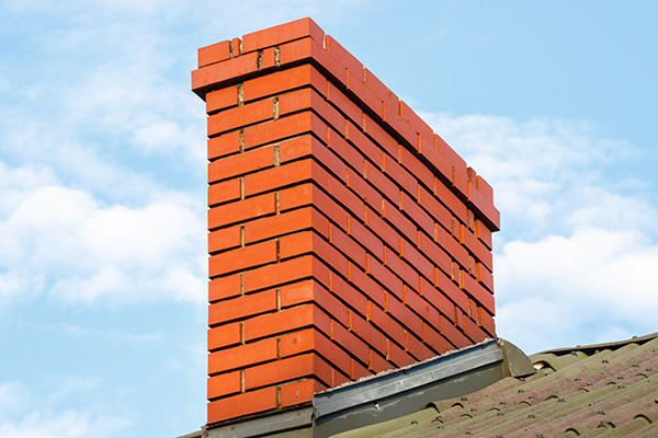 Brick chimney on roof of residential house on sunny day